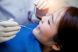 © WITTAYA - Young man dentist who treats teeth of young woman patient.