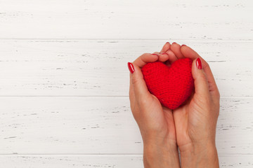 Woman hands holding red heart toy