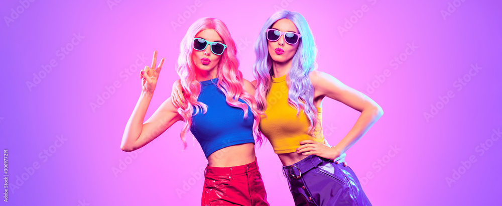 Gorgeous Disco Party girl with Having Fun, neon style. Pink Purple hairstyle. High Fashion. Two young beautiful model woman friends Dance, colorful neon Light. Night Clubbing.Pop Art fashionable Style - obrazy, fototapety, plakaty 