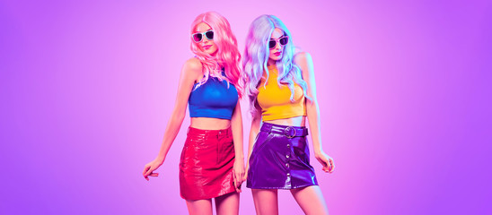 two sexy adorable fashion woman in party outfit dance, trendy neon light hairstyle. night club vibes