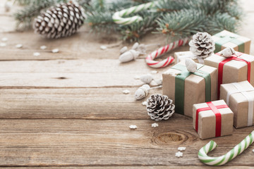 Christmas green branch and gifts on  wooden background