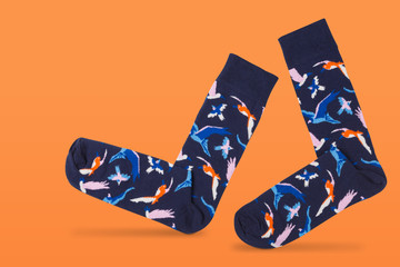 a pair of blue socks, on an orange background, as if walking, concept, comfort