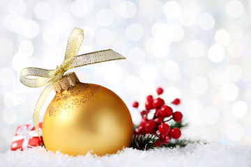 Canvas Print - Christmas bauble with ribbon bow and red berries on blurred background