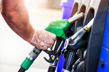 Man holding pump and refueling gasoline at gas station.Petrol filling into car tank.