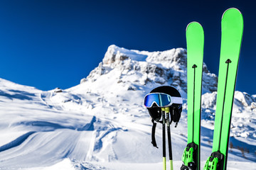 Skis in snow, mountains and ski concept equipments in sunny winter day. Fresh or new groomed slope at best piste resort.