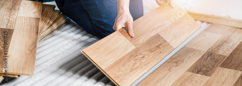 Fotografía Worker hands installing timber laminate floor