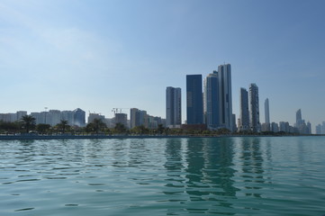 Wall Mural - Abu Dhabi city skyline along Corniche beach taken from a boat