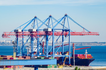 Port cargo crane loads a container onto a cargo ship