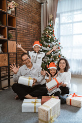 Wall Mural - beautiful grandparents and grandchildren portrait smiling to camera on christmas day at home