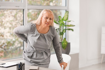 Sticker - Mature woman suffering from back pain in office