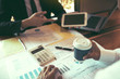 © wutzkoh - Two businessmen are working analyzing the company annual budget and using digital tablet to find information data result.