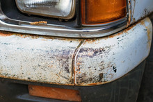 Colse Up To Decay And Rust On The Front Bumper Of An Old White Truck. Rust Hole On Old Worn Painted Metal Surface.