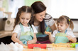 © Oksana Kuzmina - Happy family mother and kids preparing bakery together. Mom and children having fun cooking cookies in the kitchen. Homemade food and little helpers.