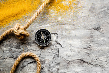 Wall Mural - Goal achievement concept. Compass near rope with knot on grey background top view copy space