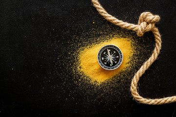Wall Mural - Goal achievement concept. Compass near rope with knot on black background top view copy space