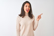 © Krakenimages.com - Beautiful chinese woman wearing turtleneck sweater standing over isolated white background with a big smile on face, pointing with hand finger to the side looking at the camera.
