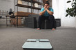 © New Africa - Scales and depressed overweight man on floor at home