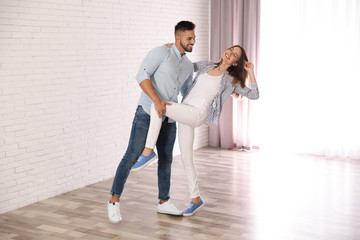 Wall Mural - Lovely young couple dancing together at home