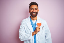Young Indian Doctor Man Holding Paper Heart Standing Over Isolated Pink Background With A Happy Face Standing And Smiling With A Confident Smile Showing Teeth