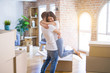 © Krakenimages.com - Young beautiful couple hugging at new home around cardboard boxes