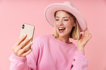 Poster - Portrait of charming woman in hat smiling while taking selfie photo