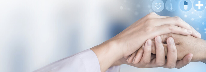 healthcare bannner background with doctor hand holding patient hand over hospital background