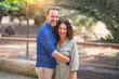 © Krakenimages.com - Middle age beautiful couple smiling happy and confident at town park. Standing with smile on face and hugging