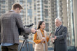 © zinkevych - Female reporter in beige outfit asking questions to a grey-haired man