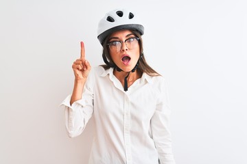 Wall Mural - Beautiful businesswoman wearing glasses and bike helmet over isolated white background pointing finger up with successful idea. Exited and happy. Number one.