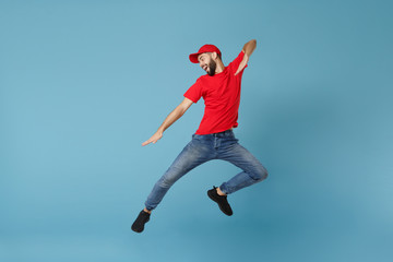 Wall Mural - Delivery man in red uniform workwear isolated on blue wall background, studio portrait. Professional male employee in cap t-shirt print working as courier dealer. Service concept. Mock up copy space.