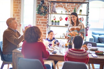 Wall Mural - Beautiful family smiling happy and confident. One of them standing showing roasted turkey celebrating christmas at home