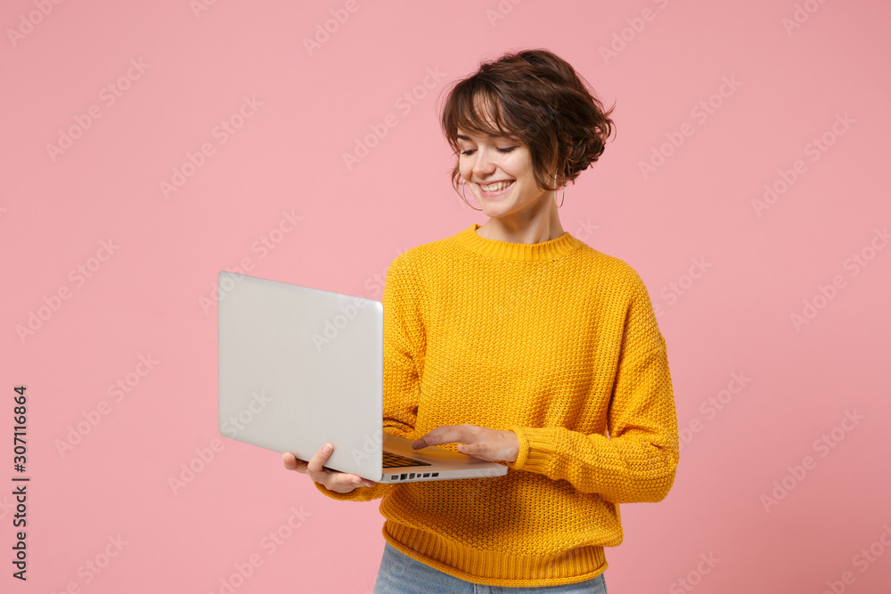 Smiling young brunette woman girl in yellow sweater posing isolated on ...