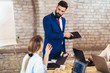 © Mediteraneo - Portrait of a young businessman giving presentation to his colleagues in office.