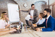 © Mediteraneo - Portrait of a young businessman giving presentation to his colleagues in office.