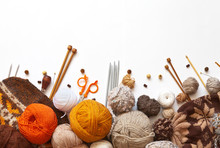 Tangles Of Orange, Brown And Beige Wool Yarn For Hand Knitting, Accessories For Knit, And Knitted Hats On A White Background. The Concept Of Crafts And Hobbies. Copy Space, Flat Lay, Mock Up