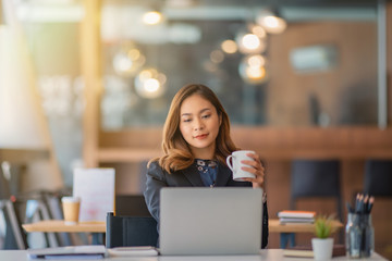 businesswoman having tea or coffee in home office