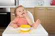 © Lisa Tichané - Happy toddler eating pasta in high chair with foot on table