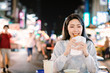 Asian woman enjoy  Chicken Fillet with street food in  Night Market