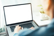 © panitan - mockup image blank screen computer with blank white background for advertising text,hand man using laptop contact business search information on desk at home office.marketing and creative design