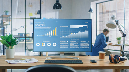 Wall Mural - shot of a desktop computer in the creative modern office. monitor screen shows company growth data w