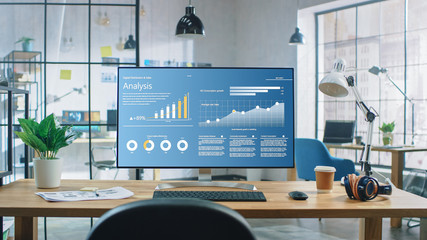 Wall Mural - shot of a desktop computer in the creative modern office. monitor screen shows company growth data w