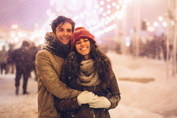 Couple Hugging Smiling At Camera Standing On Christmas Market Outdoor