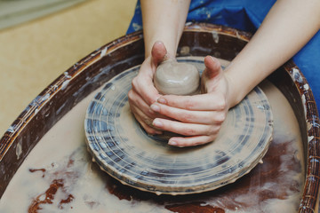 Wall Mural - Woman hands on pottery wheel. Craftsman artist shapes pot