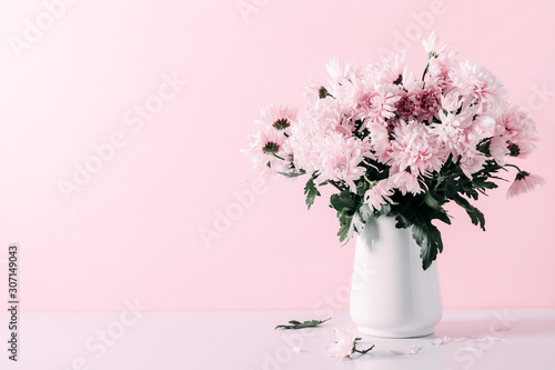 Fotografía Fresh bouquet of pink flowers in vase on white shelf on pink wall background