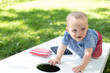 little kid playing cornhole in summer