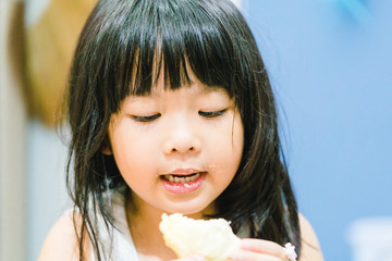 Wall Mural - 5 years old girl.Little asian thai girl eating durian fruit at home.She make every happy and yummy face.First time with durian.Durians are the king of fruits.