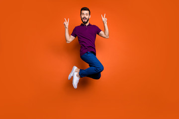 Full length body size turned photo of cheerful excited handsome man showing double v-sign in blue pants white foot wear isolated vivid color background