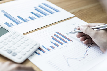 Business men analyze financial data for the company's revenue with graphs and calculators, accounting concept