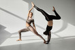 © LIGHTFIELD STUDIOS - Young women practicing acroyoga in sunny studio