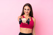 © luismolinero - Young sport girl over isolated pink background making weightlifting